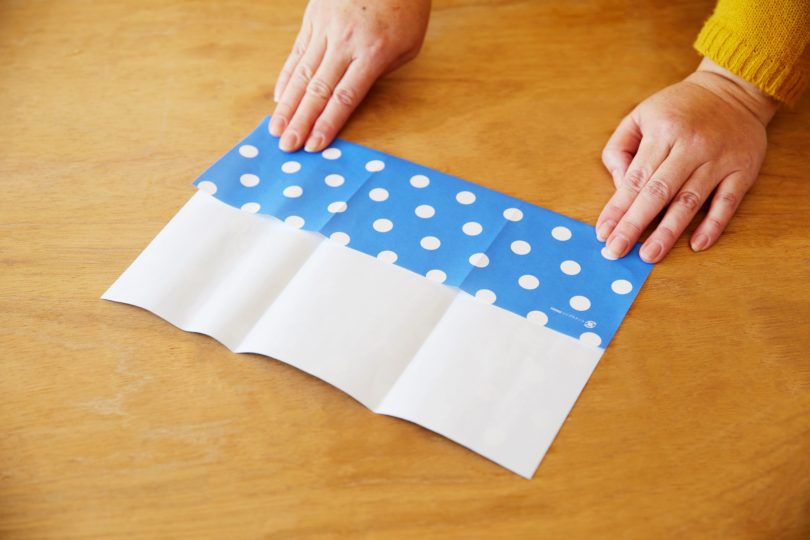 包装紙の柄のない面を表にし、タテの三つ折りにする。