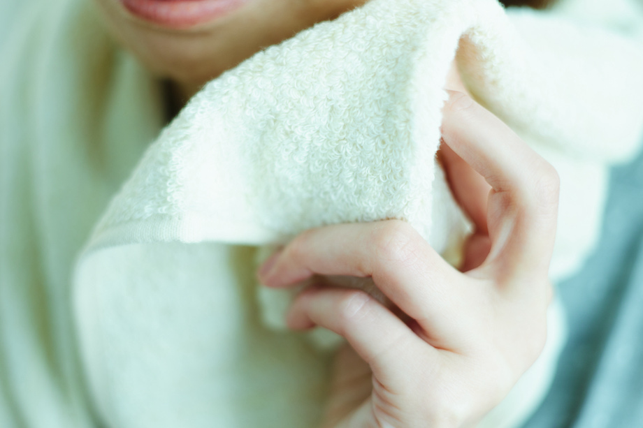 タオルで顔を拭く女性