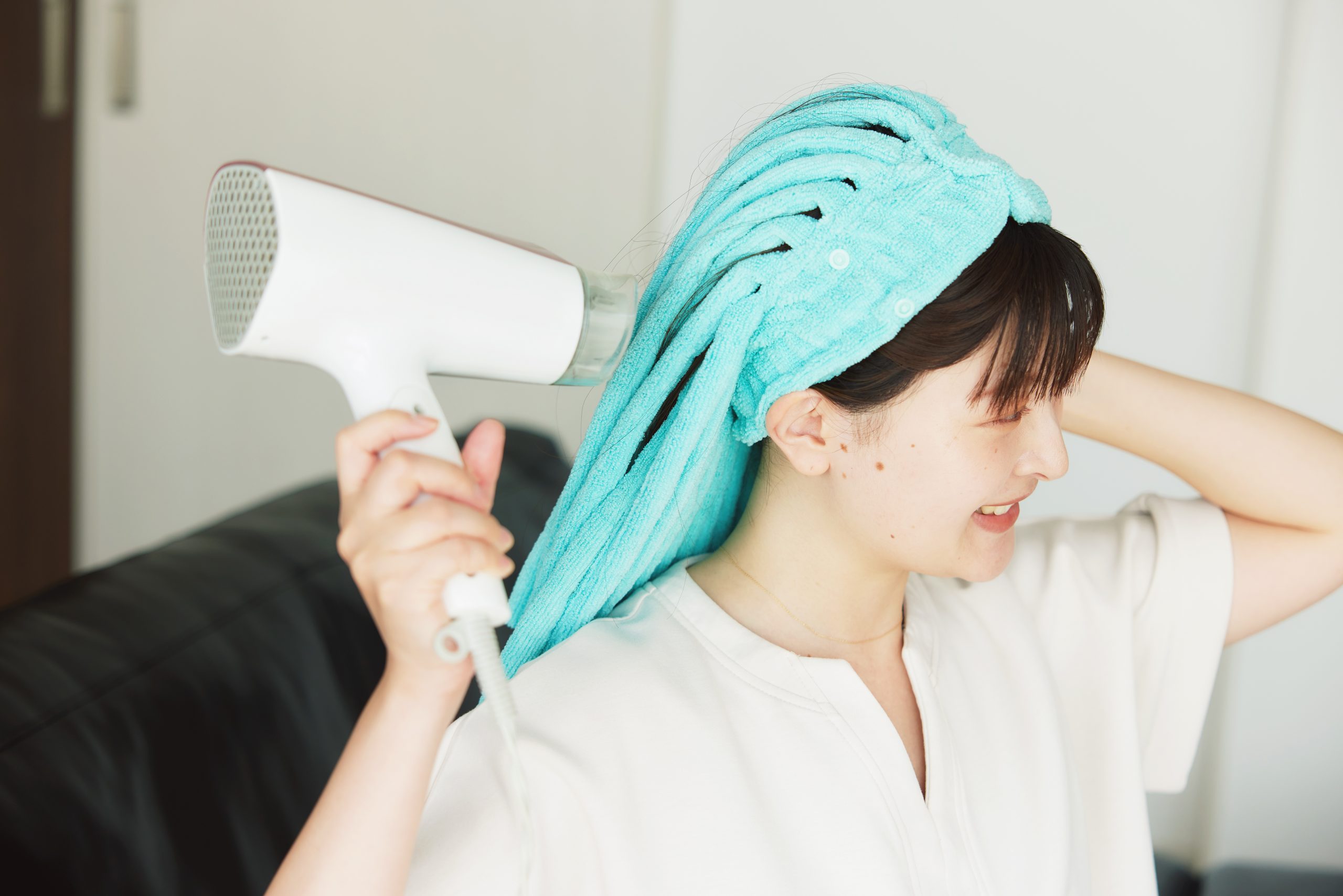 ぱすたおを使って髪を乾かす女性